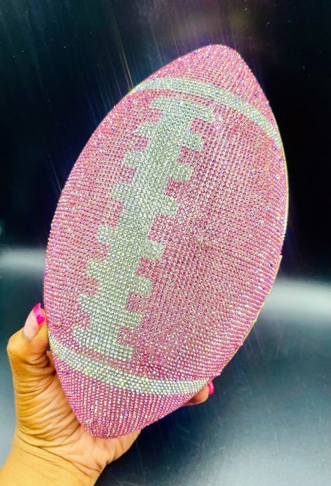 "Get ready to turn heads at your next tailgate party with our sparkling rhinestone football purse! This conversation starter is not only a unique fashion statement but a versatile accessory that will add some serious sparkle to your game day attire. Handcrafted with meticulous attention to detail, this light-reflecting handbag is perfect for the fashion-forward football lover in your life. Our clutch is designed in the shape of a football, completely encrusted with shimmering rhinestones. Availa Bedazzling Stuff, Football Purse, Rhinestone Football, Bling Ideas, Rhinestone Projects, Stadium Bag, Rhinestone Crafts, Bling Crafts, Football Lover