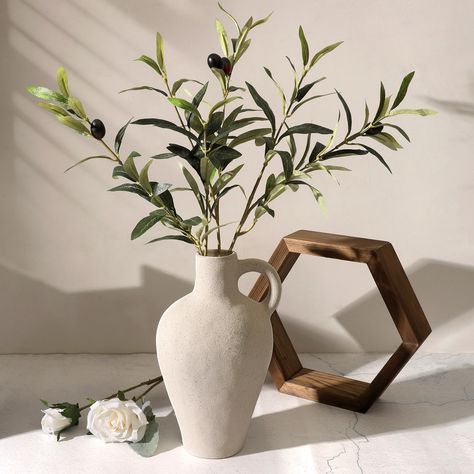 PRICES MAY VARY. Natural Home Decor: This is a vintage and modern ceramic vase with a large olive branches, evoking the serene charm of the Mediterranean coast with removable greenery stem, so this piece can be used throughout the year Durable Quality: Crafted from premium materials and featuring polished and smooth bottom for surface protection, our textured vase ensures lasting elegance in your home with lifelike faux olive stems Perfect Size: Approx 21.8" tall, measuring from the bottom of th Natural Vases Decor, Faux Branches In Vase, Table Plants Decor, Vase With Olive Branches, Branches (craft Supplies), Living Room Centerpiece, Home Decor Floral Arrangements, Greenery Plants, Vase With Branches