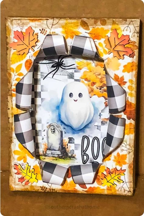 Halloween-themed artwork with a happy ghost, tombstone, spider, “boo” text, and autumn leaves peeling back checkered paper. Canvas Diy Ideas Crafts, How To Do Busted Canvas Crafts, Break Through Canvas, Altered Canvas Tutorial, Split Canvas Art, Breakout Canvas Craft, Bust Out Canvas Ideas, Halloween Busted Canvas Ideas, Break Out Canvas