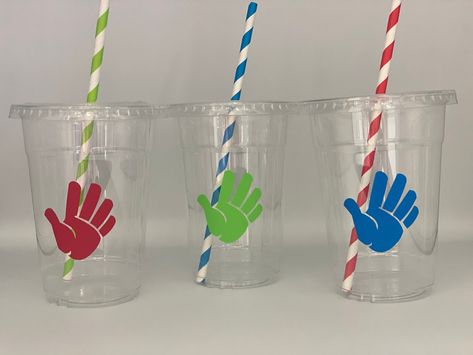 These are great for an high five inspired party. Each cup is 16 oz. and made from a sturdy disposable plastic. These are decorated with vinyl stickers and come with matching paper straws and lids. These are perfect for small children who easily spill. You can also stuff these with candy, snacks, and little toys for a great party favor.  Cup Color: Clear, disposable Cup size: 5 inches without straw Vinyl color: red, green, blue Straw: Matching Paper Straw Please click the amount button to see pricing on these cups. If you want a different amount then what is available please message me for a custom listing.  I can also customize these cups. If you would like a child's name on each cups it is an extra $0.25 per cup. Just add this listing along with your order of cups: https://www.etsy.com/li High Five Theme Party, High Five Birthday Party Cake, High 5 Birthday Party Theme Boy, Hi 5 Birthday Party Ideas, Hi Five Birthday Party Ideas, High 5 Birthday Party Theme, Officially A Handful 5th Birthday, High Five Birthday Party, Ninja Birthday Party Favors