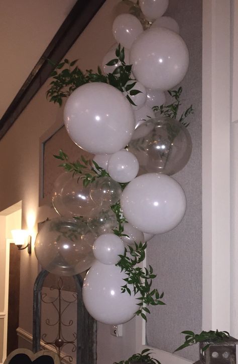 Balloon Swag with greenery - great for DIY. Mixture of white and clear balloons strung together with monofilament fishing line. Poets Laurel (greenery) tucked into gaps. Don't use lungs to inflate clear balloons...will fog. Balloons With Vines, Balloon Reception Decor, Clear And White Balloons, White And Green Bachelorette Party, Minimalist Balloon Arch, White And Clear Balloon Garland, Balloon Arch Wedding Receptions, White Balloons With Greenery, Floating Balloon Decorations