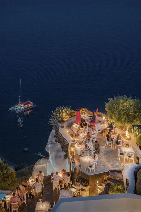 A night photo of Lycabrttus Restaurant, which is located on a cliff in Oia, Santorini Santorini Romantic Dinner, Greece Party, Oia Santorini, Family Vacay, Summer Getaway, Luxury Suite, Four Seasons Hotel, Forest House, Travel Inspo