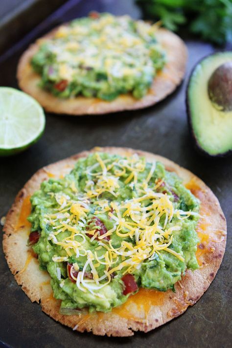 Cheesy Guacamole Tostadas Recipe on twopeasandtheirpod.com These easy and cheesy tostadas only take 20 minutes to make! They are great for an easy dinner or snack! Guacamole Tostadas, Baked Tostadas, Tostadas Recipe, Meatless Dishes, Bowl Party Food, Veggie Meals, Mexican Foods, Savoury Recipes, Superbowl Party Food