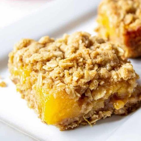 Delicious Peach Crumb Bars made with peaches and an oatmeal crust and topping. These delicious bars can be made with fresh, frozen or canned peaches. An easy to make dessert with ingredients you probably already have. Peach Oatmeal Bars, Peach Crumb Bars, Peach Bars, Peach Pie Bars, Peach Crumble Bars, Oatmeal Crust, Peach Filling, Peach Oatmeal, Fresh Peach Pie