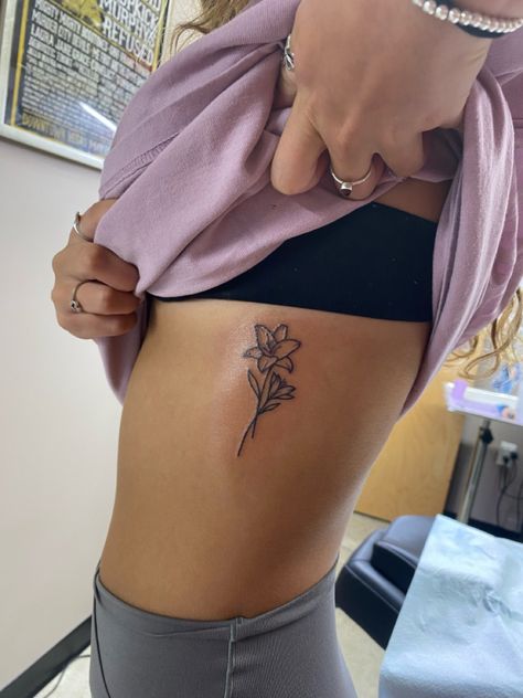 Tiny Lily Flower Tattoo, Lily Flower Rib Tattoo, Tattoo Ideas Female Lily Flower, Lillies Tattoo Designs, Lilly Name Tattoo, Daylillies Tattoos, Flower Bouquet Tattoo Hip, Tattoo Of Lily Flower, Lower Side Stomach Tattoos Women