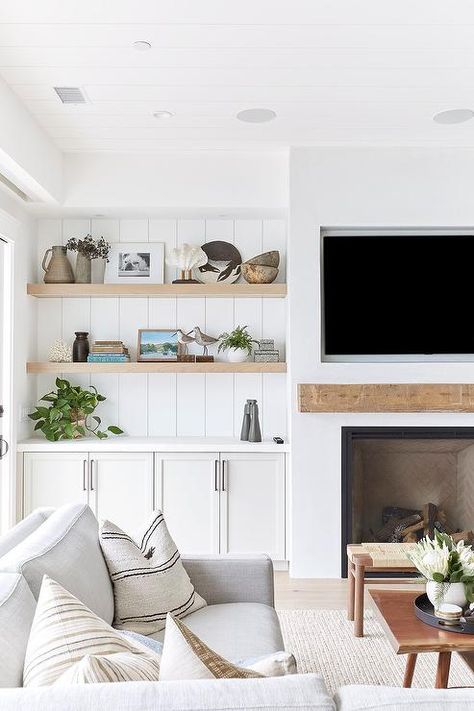 Vertical shiplap behind built-in wooden floating shelves in a cottage living room flanking a white fireplace with a wood mantel and mounted TV. Pure Salt Interiors, Modern Farmhouse Living Room Decor, Built In Shelves Living Room, Living Room Built Ins, Fireplace Built Ins, White Fireplace, Cottage Living Rooms, Modern Farmhouse Living Room, Neutral Living Room