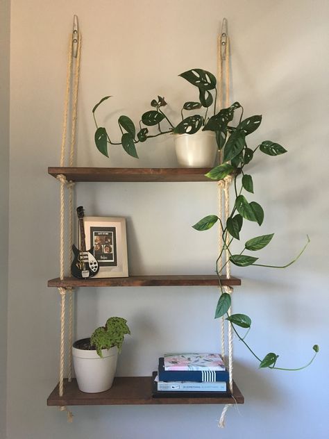 Handmade wooden and rope hanging shelves, perfect for showcasing your favorite items, while utilizing valuable wall space...and in our case, keeping plants away from our cats. This versatile piece adds a beautiful rustic/nautical touch to any room! Great for: -Bedrooms, to display photos and keepsakes -Bathroom to hold towels, tissue paper and toiletries  -Living room or office, for books and beautiful plants  -Kitchen for coffee mugs, spices and cook books Shelves are made with pine, and natural sisal rope. Each piece is made to order, so there may be slight variances. The shelving unit pictured is English Chestnut, but we offer various other options. When placing your order, please make note of which finish you would like in the notes. We also do take custom orders! If you would like to Hanging Rope Shelves, Wooden Planter Boxes, Rope Shelves, Wooden Drawers, Wooden Planters, Three Tier, Hanging Rope, Hanging Shelves, Room Ideas Bedroom