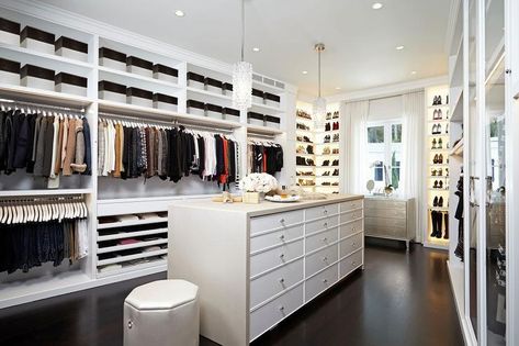 Closet island with a light gray waterfall countertop in a stunning walk-in closet boasting two hanging lights and a white leather stool. Wardrobe Island, Closet With Island, Glass Wardrobe Doors, Closet Design Plans, Gray Closet, Transitional Closet, Dream Dressing Room, Waterfall Countertop, Closet Features