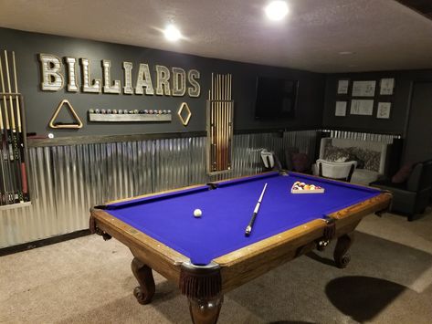 Basement billiards room with lounge areas and a wet bar. Pool table has a purple felt. Garage Billiard Room, Pool Table Basement Bar Areas, Billiard Room Decor Ideas, Pool Table Entry Room, Basement Billiard Room, Basement Game Room Decor, Basement Ideas With Pool Table, Basement Ideas Pool Table, Garage With Pool Table