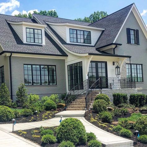 Gray painted brick with black windows and look at that roof line ... 🤩 Note on the second photo the white board and batten garage out back.… Brick With Black Windows, Brick House With Black Trim, Gray Painted Brick House, House With Black Windows, House With Black Trim, Grey Painted Brick, Grey Brick Houses, Black Windows Exterior, Grey Exterior House Colors