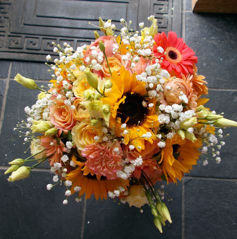 Bouquet of roses, gerberas and sunflowers in tones of coral and yellow Sunflower Bouquet With Pink, Sunflower And Pink Flower Bouquet, Sunflower And Gerber Daisy Bouquet, Sunflowers And Pink Roses, Sunflower And Peach Rose Bouquet, Peach Wedding Decorations, Sunset Theme, Sleeping Beauty Wedding, Spring Wedding Bouquets