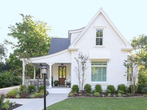 Location: Bentonville, AR Built in: 1904 Size: 3,200 sq. ft. Paint colors: (house) White Dove, Benjamin Moore "It was our dream to restore an old home," say homeowners Shelley and Kevin Kraning. They love the original details like the diamond-patterned shingles on the awning over the window and the lamppost. A front-facing gable is a common feature of Folk Victorians like this one. The Kraning's found ornate corbels at a local flea market; even though they aren't orginal, they look right at h White Shingle House Exterior, Cottage Windows Exterior, White Cottage Exterior, Cottage Exterior Ideas, White Victorian House, White Dove Benjamin Moore, Gable Pediment, Ranch Houses, White Siding