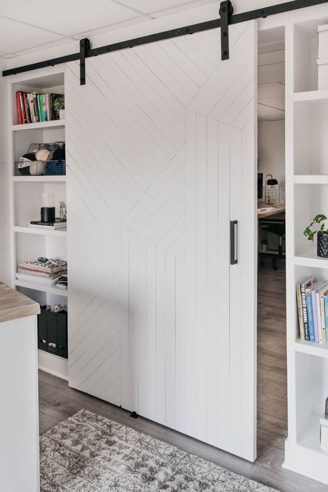 DIY Modern barn door over built in shelving. This blog studio and office is white, bright, and full of DIY storage… all out of a dingy unfinished basement! Welcome to my basement studio reveal! Do you even remember what this space was before? It was a cold, completely unfinished basement full of storage, storage, and more storage. And now? It’s a literal dream, you guys. | basement studio ideas | basement renovation | basement office studio #basement #basementrenovations #renovationinspiration Basement Storage Door Ideas, Hiding Utilities In Basement, Hidden Basement Storage, Basement Office Ideas No Windows, Basement Studio Ideas, Basement Door Ideas, Diy Modern Barn Door, Renovation Basement, Studio Basement