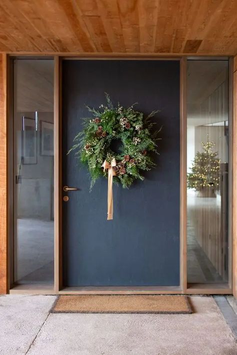 a lush modern Christmas wreath with lush greenery, some white blooms, pinecones and a peachy pink ribbon bow Modern Christmas Wreath, Modern Jul, Philippa Craddock, Fir Cones, Christmas To Do List, Wreath Ribbon, Decorated Wreaths, Ribbon Ideas, Christmas Wreaths To Make