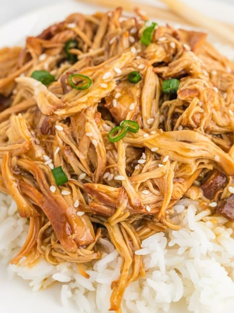 A white plate with white rice topped with teriyaki chicken, green onions, and sesame seeds. Chopsticks in the background. Shredded Chicken Teriyaki Bowl, Shredded Chicken Over Rice, Shredded Chicken Rice Bowl, Shredded Chicken Teriyaki, Asian Shredded Chicken, Shredded Chicken Bowls, Shredded Chicken And Rice, Gym Baddie, Bourbon Chicken Crockpot