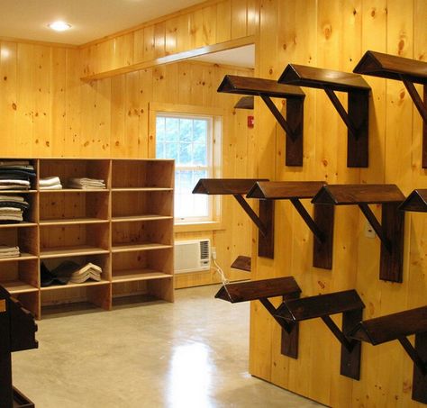 Saddle wall and saddle pad cubby of show team tack room Saddle Racks Tack Room, Wall Saddle Rack, Tack Room Saddle Rack, Fancy Tack Room, Tack Up Area, Saddle Pad Storage, Saddle Room, Tack Room Organization, Feed Room