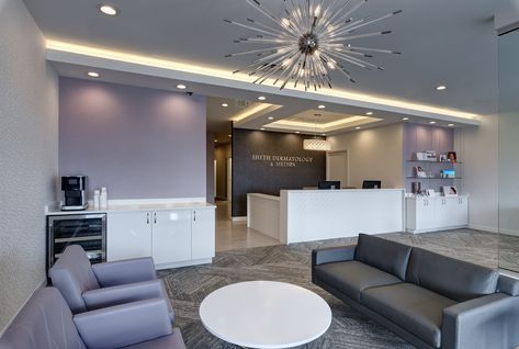 This upscale 3,500 SF Dermatology Office reflects sophisticated glamour.  The space contains modern features such as white gloss cabinetry, contemporary accent lighting, an innovative barn door system, and sparkling retail displays.  Champagne bronze accents add a chic element to the space, while the main corridor features a central diamond flooring pattern and up-lit soffit guiding patients to a secondary waiting room. Doctor Office Design, Apex Design, Dermatology Office, Medical Office Decor, Aesthetic Dermatology, Dermatology Clinic, Office Waiting Rooms, Medical Office Design, Clinic Interior Design