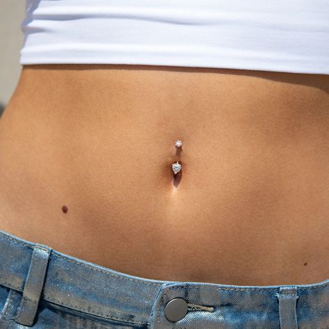 The 6x6mm heart-shaped moissanite belly ring is the perfect blend of sophistication and sensuality. There's something beautiful and intriguing about the way a heart-shaped gemstone complements the navel's natural form. The fiery sparkle of the moissanite truly sets this belly ring apart. For a perfect fit, consult our Piercing Concierge™. We offer personalized bar lengths in 18 sizes, ranging from 5mm to 14mm, including every whole and half size in between. Charms do not attach to this ring. Mat Belly Button Piercing Small Simple, Minimalist Belly Button Piercing, Heart Belly Piercing, Cute Belly Button Piercing, Dangle Belly Button Piercing, Belly Button Piercings, Belly Piercings, Gold Belly Ring, Navel Jewelry