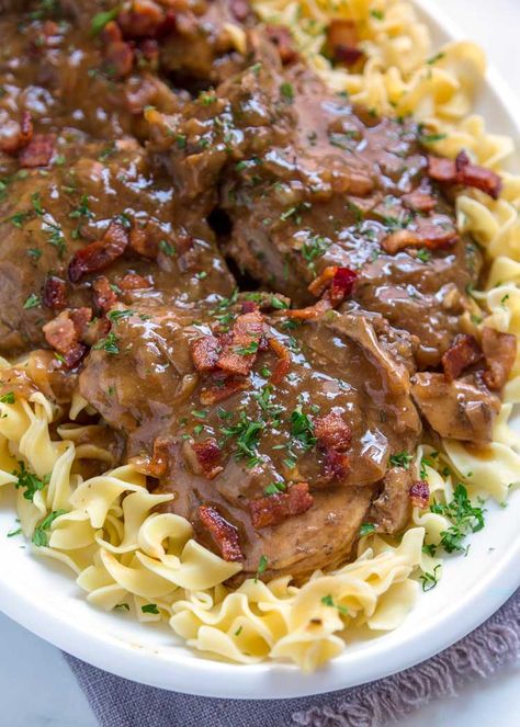 These Slow Cooker Smothered Pork Chops are so tender and the onion gravy that smothers them is rich, savory and loaded with bacon. Serve over noodles. Pork Chops And Gravy Instant Pot, Instapot Smothered Pork Chops, Pork Chops Onion Gravy, Pressure Cooker Smothered Pork Chops, Instant Pot Smothered Pork Chops With Cream Of Mushroom Soup, Smothered Pork Chops Recipe, Pressure Cooker Pork, Instant Pot Pork Chops, Pork Chop Recipes Crockpot