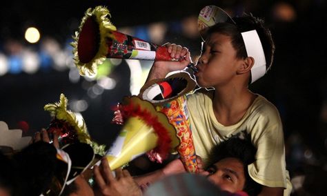 Davao, southern Philippines: A Filipino boy blows his Torotot (party blower) for a new year's attempt to break the Guinness book of World Record for the "Most number of people blowing party blowers simultaneously". Photograph: Ritchie B. Tongo/EPA Filipino New Year, Philippine Traditions, Christmas In The Philippines, Party Blower, Cavite City, Party Blowers, Haha Photos, Philippines Culture, New Years Traditions