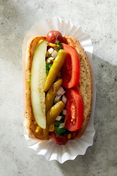 A proper Chicago dog is an all-beef frankfurter (such as Vienna Beef) in a poppy seed bun, topped with yellow mustard, neon-green sweet pickle relish, chopped white onion, tomato slices, a dill pickle spear, pickled sport peppers, & celery salt. If you can’t find Chicago-style sport peppers, then sliced pepperoncini works in a pinch. Don’t skip the celery salt; its herbal lightness makes these dogs shine. And don't even think of putting ketchup on it 😁 Chicago Hot Dog Recipe, Plum Dessert, American Chinese Food, Hot Beef Sandwiches, Desserts Drinks, Chicago Style Hot Dog, Dog Restaurant, Chicago Hot Dog, Illustrative Design