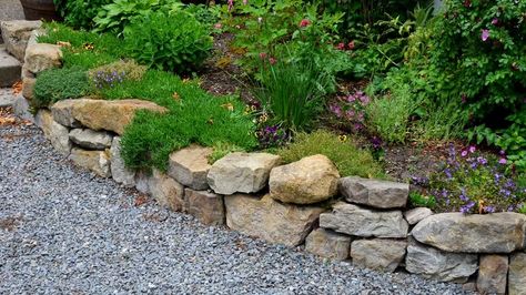 20 Stone Retaining Walls That Will Look Amazing In Your Yard Rock Retaining Wall Ideas, Garden Bed Wall, Backyard Border, Gabion Stone, Boulder Retaining Wall, Rock Retaining Wall, Retaining Wall Ideas, Landscaping A Slope, Sandstone Wall