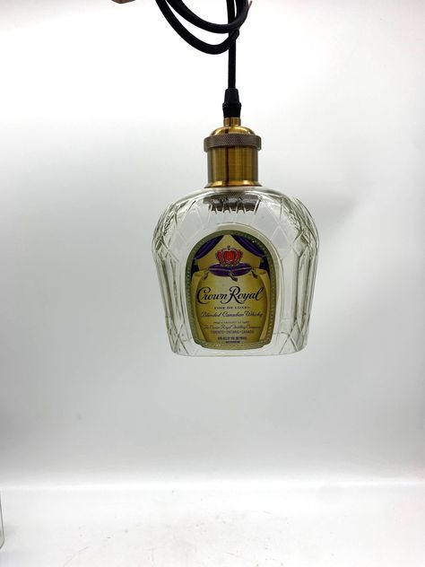 "Crown Royal® Whisky 1L Bottle Pendant Light, Cut and Sanded. Dimensions: 3.25x5.5x8\" approx. Material: Recycled Crown Royal® Whisky 1L bottle A set includes:  1 cut and sanded bottle * 1-meter 18AWG light cord * standard medium-base light socket (E27) * NO CANOPY OR LIGHT BULB INCLUDED  For indoor setting only Don't see the Brand you want? Just convo us, and we will create the perfect item for you! With over 10,000 empty bottles in stock, we can't list all of our bottles here on Etsy, but if y Crown Royal Lamps, Canadian Whiskey, Bottle Pendant Light, Crown Royal Bottle, Table Island, Garage Designs, Hanging Light Lamp, Bottle Chandelier, Fall Pumpkin Crafts