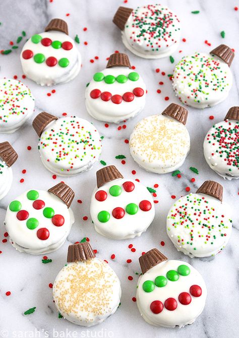 Oreo Ornaments – Oreo cookies dipped in white chocolate and decorated to look like a holiday ornament with peanut butter cup minis, and festive candies and sprinkles; stress-free Christmas cookie perfection. Oreo Ornaments, Cookies Dipped In White Chocolate, Oreo Sandwich, Oreo Cookies Dipped, Easy Christmas Treats, Christmas Candy Recipes, Peanut Butter Cup, Christmas Food Desserts, Xmas Cookies