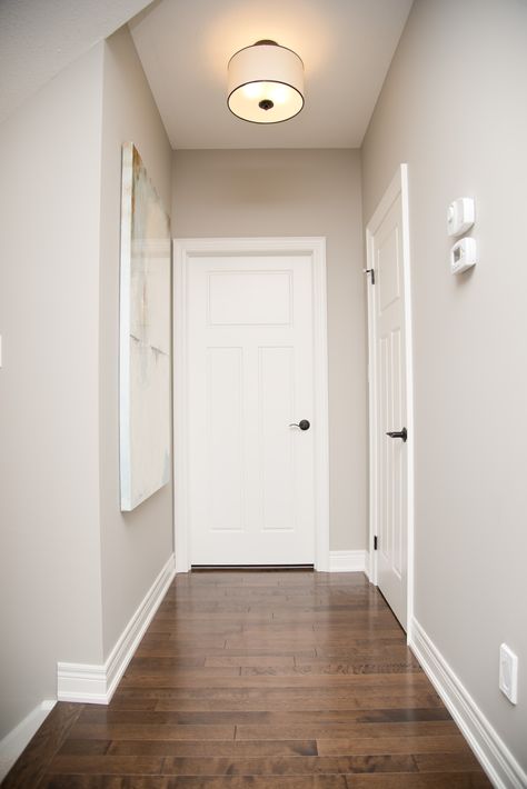 A neutral wall colour paired with bright white trim complemented this flooring beautifully. #parliamentpainting #housepainting #homedesign #hamont Internal House Paint Colors, White Wall And Door Color Combination, Internal Paint Colours Wall Colors, Door And Wall Colour Combination, Color Trim White Walls, Wall Painting Colour Combination Living Rooms, Wall And Floor Color Combination, Neutral Paint Colors For Living Room, Floor And Wall Color Combinations