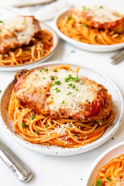 This Chicken Parmesan recipe is made with perfectly seasoned crispy chicken topped with a simple homemade tomato sauce and sliced mozzarella cheese. Pan-seared to develop the crust, then finished in the oven, we love to serve our chicken parm with spaghetti cooked just until al dente and tossed in more of the homemade sauce. #chickenparm #chickenparmesan #chickenparmigiana Spaghetti And Chicken Parmesan, Chicken Parmesan With Pasta, Chicken Parmesan With Spaghetti, Chicken Parm Recipes, Saucy Chicken, Chicken Parmesan Recipe Easy, Chicken Parmesan Recipe, Parmesan Recipe, Chicken Parmesan Pasta