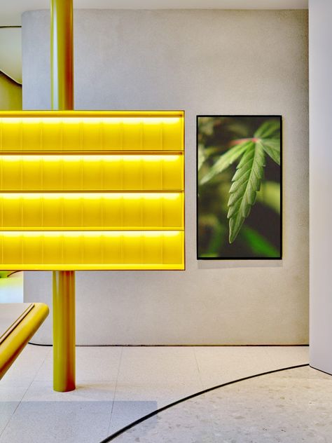 Colourful freestanding shelving displays, made out of resin dyed bright yellow, project out from slim columns. Walled Courtyard, Sea Containers, Plant Installation, Mirror Ceiling, Yellow Lamp, Ceiling Texture, Marble Tile Floor, Shelf Lighting, Orange Walls