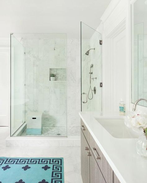 A turquoise blue Greek key rug sits on marble floor tiles in front of a gray wood washstand accented with nickel pulls and a white quartz countertop fitted with a sink with a polished nickel gooseneck faucet. 100 Year Old House, Dutch Colonial Homes, Refinish Bathtub, Marble Tile Floor, Dutch Colonial, White Quartz Countertop, Blue Bathroom, Coffered Ceiling, Modern Light Fixtures