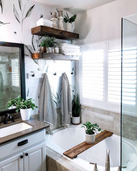 The wall behind a soaking tub is often wasted, but not here! The designer hung an additional towel rack under floating shelves to accommodate full-size towels right by the bathtub. No more stepping out of the bath and walking across the room to access the towels! The stripes and fringe on the towels also pair perfectly with the leafy wallpaper, a functional and decorative feature of the space. Towel Rack Over Bathtub, Bathtub Towel Rack, Towel Rack Above Tub, Bathtub With Shelves, Shelves Above Bathtub, Display Towels, Luxurious Bathtubs, Master Bath Renovation, Linen Closets