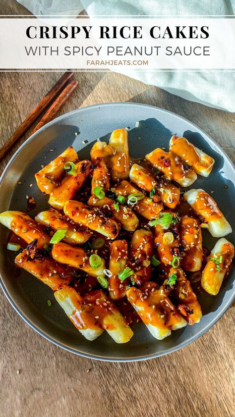 Plated crispy tteokbokki rice cakes with spicy peanut sauce, garnished with green onions and sesame seeds. On the side is a pair of wooden chopsticks and a white kitchen towel. Tteokbokki Rice Cakes, Tteokbokki Recipe Easy, Crispy Rice Cakes, Tteokbokki Recipe, Rice Cake Recipes, Korean Side Dishes, Spicy Peanut Sauce, Crispy Rice, Peanut Sauce