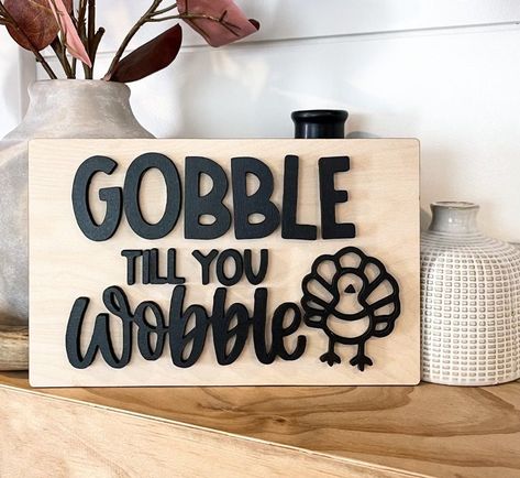 "This all 3D eye catching Gobble til you wobble funnyThanksgiving sign is wood.  This is a great gift sign for the cook at Thanksgiving. Such a true humorous Thanksgiving sign for any room. This wood Turkey sign can be hung or placed on a shelf. This cute Thanksgiving sign is on natural Baltic birch board with all black 3D raised wood lettering size is 5\" high x 8\" long. 😀click here to see matching wood pumpkin name engraved place cards: https://www.etsy.com/listing/878846373/fall-table-decorhome-decor-fall-table?click_key=2d97637e6c686f2450541b6511edae254bcd6d74%3A878846373&click_sum=a2adf8e0&ref=shop_home_active_272&sts=1 📸 Please follow us on IG@stokesdesignshop and tag us in your photos!  Please watch shipping time closer to HOLIDAYS RUSH MY ORDER UP -1-3 business days to have read Thanksgiving Signs And Sayings, Wood Turkey, Wood Lettering, Thanksgiving Sign, 3d Eye, Fall Wood Crafts, Dog Thanksgiving, Gobble Til You Wobble, Thanksgiving Signs