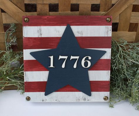 "ONLY ONE AVAILABLE AND READY TO SHIP -Custom made 4th of July sign. Great for a wall, shelf, mantle, desk, etc. -Measures 8\" x 8\" x 1 1/2\". -Stained wood and dry painted in white. -Laser cut star in navy and 1776 in white. -Sealed with polycrylic (matte finish). -Brass nail heads in corners. -Our signs are made from real wood or pallet boards as indicated above. Each sign is unique and may have imperfections including knots, nail holes, grain patterns, etc. These imperfections add character Fourth Of July Sign, Wall Art Shelf, Patriotic Crafts Diy, Art Shelf, Patriotic Sign, 50 Dollars, Shelf Mantle, 4th July Crafts, Craft Booth Displays