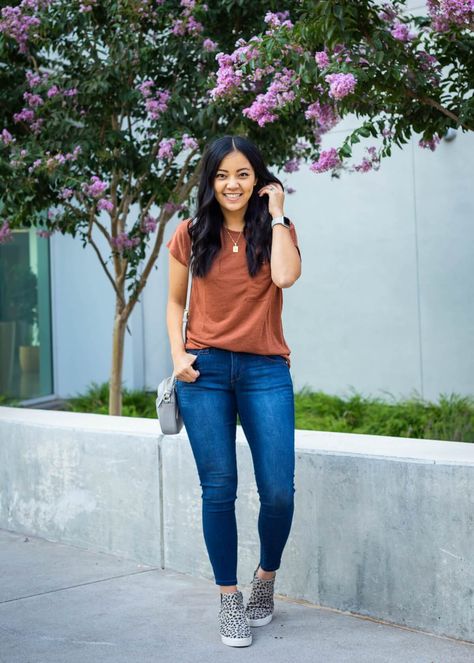 Casual Outfit: rust top + blue skinny ankle jeans + leopard sneaker booties + gold pendant necklace + gray small crossbody bag Rust Top Outfit Summer, T Shirt Jeans Outfit Casual, Rust Tshirt Outfits, Rust Top Outfit Fall, Ankle Jeans With Sneakers, Tshirt Jeans Outfit Casual Women, Gray Sneaker Outfits Women, Jeans And Tshirt Outfits Casual, Rust Top Outfit