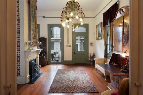 Sage green paint sets the door, window trim and molding off from the white walls, seen here in the foyer. Overhead, an elaborate chandelier twinkles like a cluster of stars. Victorian Foyer, French Quarter Decor, New Orleans Style Homes, New Orleans Decor, Dining Room Paint Colors, Shotgun House, Victorian Style Homes, Storage Inspiration, Bedroom Design Inspiration