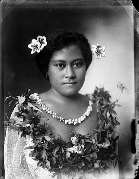 By: Andrew, Thomas Date: circa 1910  Description: An unidentified Samoan woman wearing traditional dress and frangipani flowers in her hair. She is wearing a ceremonial headdress (tuiga), and holding a wooden nifooti (cane knife). Samoan Dance, Samoan People, Samoan Women, Flowers In Her Hair, Polynesian Culture, Island Style, My Heritage, Vintage Pinup, Traditional Dress