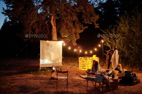 Young restful friends having drinks and watching movie on white screen outdoors by Pressmaster. Young restful friends having drinks and watching movie on white screen in the evening in natural environment while si... #Sponsored #watching, #movie, #white, #drinks Movie Night Couple, Outdoor Movie Night, White Drinks, Inflatable Lounger, Outdoor Projector, White Screen, Night Couple, Couples Retreats, Entrance Porch