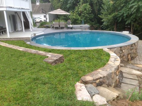 5 - Freedom above ground pool installed partially above ground with a deck section and stone surround. Slope Backyard, Affordable Pool, Radiant Pools, Pool Play, Large Backyard Landscaping, Best Above Ground Pool, Pool Kits, Above Ground Pool Landscaping, Above Ground Pool Decks