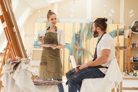 Young Woman Painting Portrait in Studio by seventyfourimages. Portrait of young woman painting picture on easel while working in sunlit art studio with bearded man sitting on chai... #Sponsored #young, #seventyfourimages, #painting, #woman Konsep Prewedding, Painter Photography, Art Studio Design, Couple Sketch, Painting Woman, Couple Painting, Painting Picture, Female Artist, Bearded Man