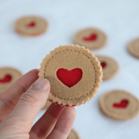 "Set of three felt cookies.  Each of these sweet little cookies is handmade with lots of love. Perfect for play kitchens, Valentine's Day décor, or gifts. Hand stitched using embroidery floss and high quality 100% recycled synthetic felt. Due to the nature of handmade goods, all measurements are approximate. Cookies are 2.25\" wide. * All items are hand crafted in a smoke free workspace. * Colors may vary slightly from what you see on your screen. * Like what you see? More options are available Felt Valentine, Felt Cookies, Felt Food Diy, Felt Food Patterns, Felt Mushroom, Linzer Cookies, Play Kitchens, Felt Play Food, Pretend Food