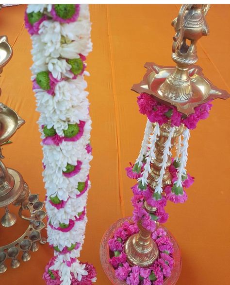 Kuthu vilakku decoration Kuthuvilaku Flower Decoration, Samai Decoration With Flowers, Samai Decoration Idea, Kuthu Vilaku Decoration, Vilakku Decoration, Vilaku Decoration, Indian Floral Decor, Diya Decoration Ideas, Indian Wedding Garland