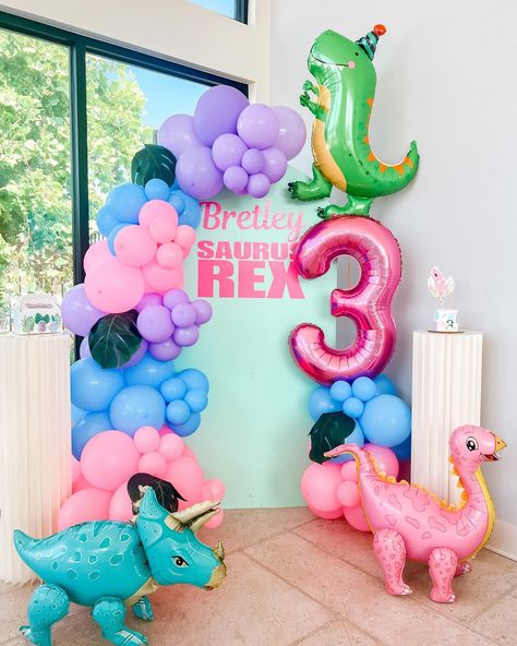 Dinosaur-themed party backdrop with balloon decorations Girls Three Rex Party, 3 Rex Birthday Party Girl, 3rd Birthday Party Theme Ideas, Three Rex Birthday Party Girl, Girly Dinosaur Party, Girl Dinosaur Birthday Party, Girls Dinosaur Birthday, Birthday Party Theme Ideas, Girl Dinosaur Birthday