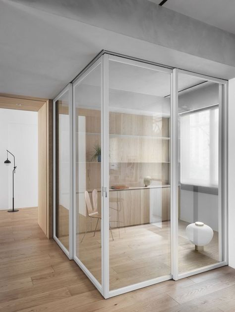 Sleek white-framed glass pocket doors enclosing a modern home office with wooden flooring and integrated furniture in Taiwan renovation. Open Home Office, Coworking Design, Open Home, Stylish Home Office, Glass Pocket Doors, Workspace Design, Pocket Doors, Office Inspiration, Glass Doors