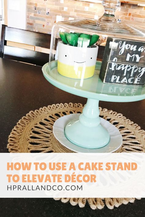 How to Use a Cake Stand to Elevate Decor from H.Prall & Co. Interior Decorating, Des Moines, IA | hprallandco.com Decorate With Cake Stand, How To Decorate A Cake Stand, Cake Stand Decor Ideas Display, Cake Dome Decor Display, Decorating With Cake Stands, Cake Plate Decor Display, Cake Dome Decor, Cake Plate With Dome, Cake Stand With Cover