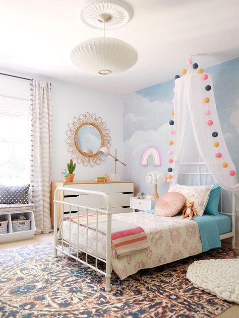 A dreamy kids bedroom decorated with a cloud mural, rainbow bedding and a colorful rug, featured in HGTV Magazine. Toddler Rainbow Room, Girls Bedroom Ideas Rainbow, Cloud Mural, Cloud Room, Cloud Bedroom, Rainbow Room Kids, White Metal Bed, Rainbow Bedroom, Rainbow Bedding