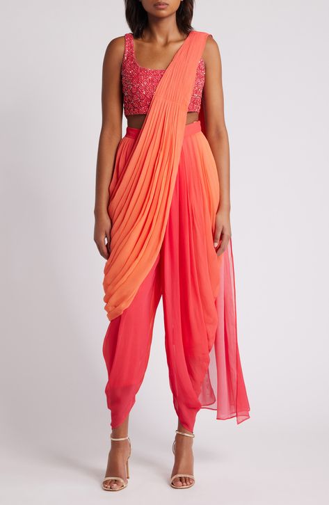 Achieve elegance in an eye-catching set that includes a hand-embroidered midriff-baring top and dance-all-night dhoti pants. The booti-work dupatta is attached to the outfit, so you don't have to worry about pleats or the right draping—just wrap it around and over your shoulder. 13" top length; 27" inseam; 14" leg opening; 17" front rise; 19" back rise Ties at back Top has scoop neck; sleeveless Side-seam pockets Pants and drape feature hook-and-eye attachments for easy adjustments Lined 100% vi Bollywood Style Pant Set With Sheer Dupatta For Festivals, Summer Party Choli With Traditional Drape, Draped Anarkali Sets For Festivals, Anarkali Draped Sets For Festivals, Navratri Draped Choli With Mirror Work, Bollywood Draped Party Sets, Designer Bollywood Draped Choli, Party Pant Set With Zari Work For Navratri, Anarkali Draped Sets For Party