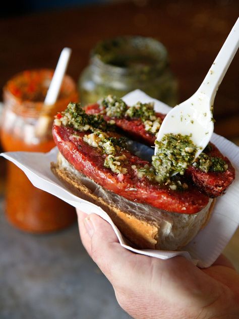 A classic Argentinian street food, the choripán consists of split chorizo on a roll with chimichurri, a sauce of herbs, garlic, olive oil, and vinegar. While sausage on a roll may not sound thrilling, a well-made chimichurri is an incredible delight that makes choripán worth tracking down. Argentinian Food, Best Sandwiches, Around The World Food, Garlic Olive Oil, Olive Oil And Vinegar, Best Street Food, Banh Mi, Fun Foods, Best Sandwich